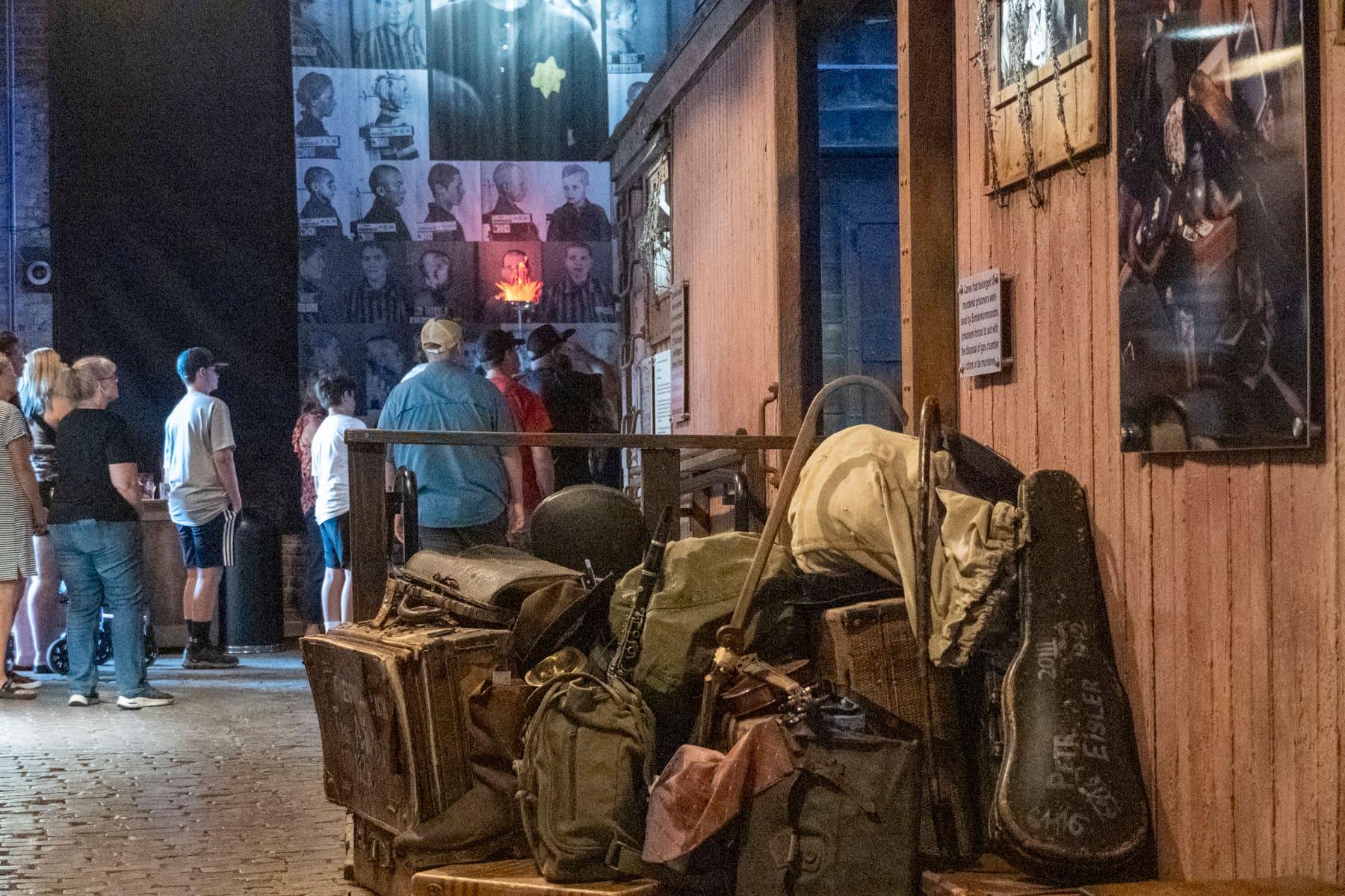 Visitors viewing displays beside historic luggage and a wooden railcar wall