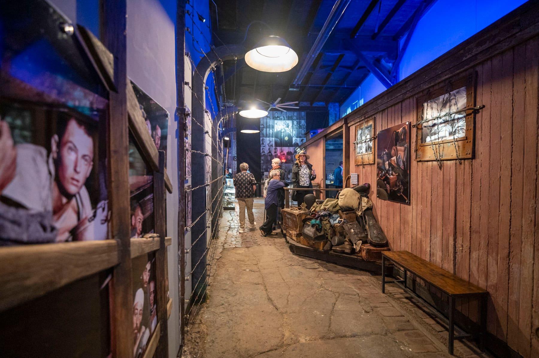 Exhibit corridor lined with historic portraits, luggage, and a wooden railcar wall