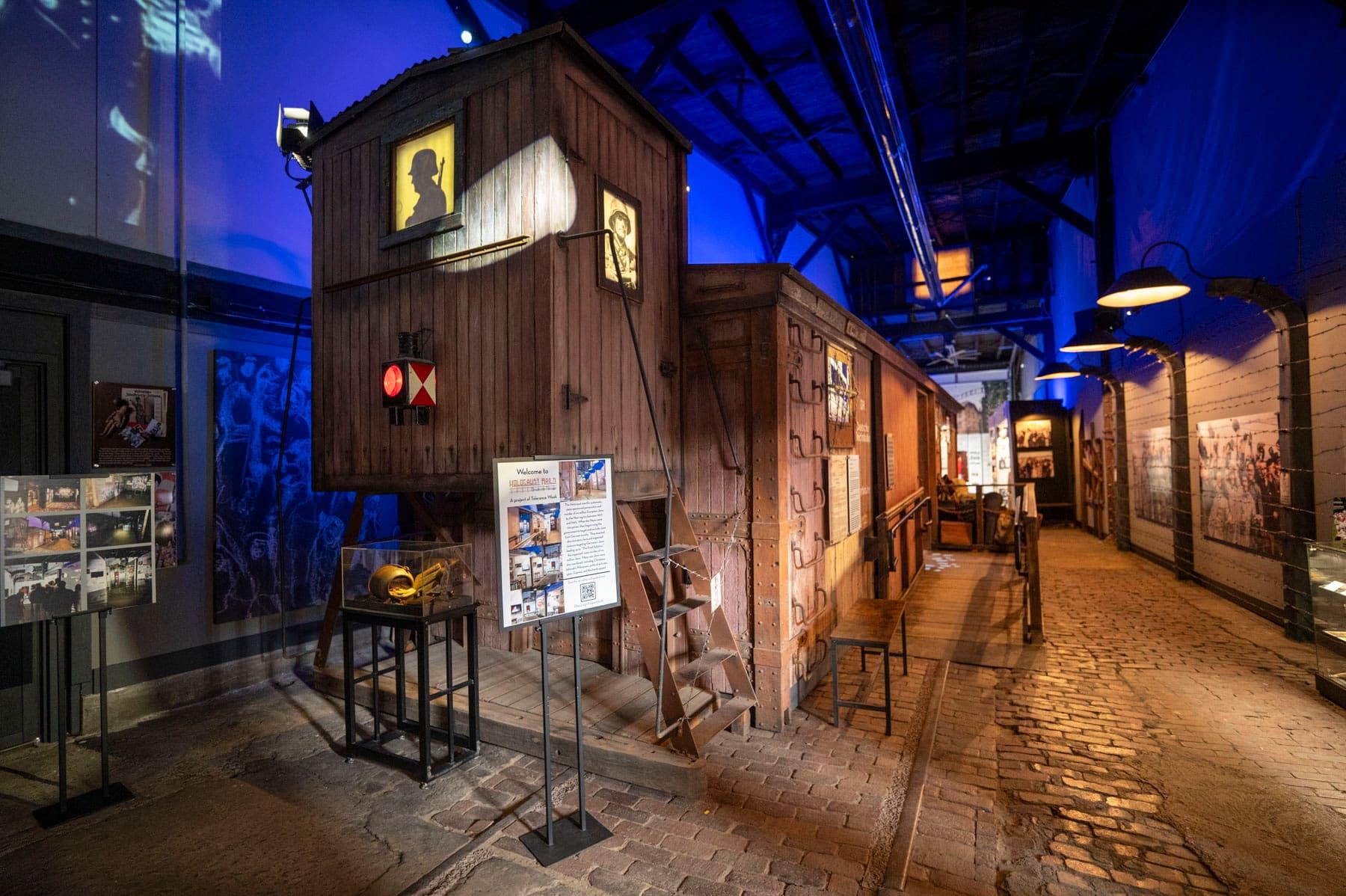 Reconstructed wooden railcar structure under blue exhibit lighting