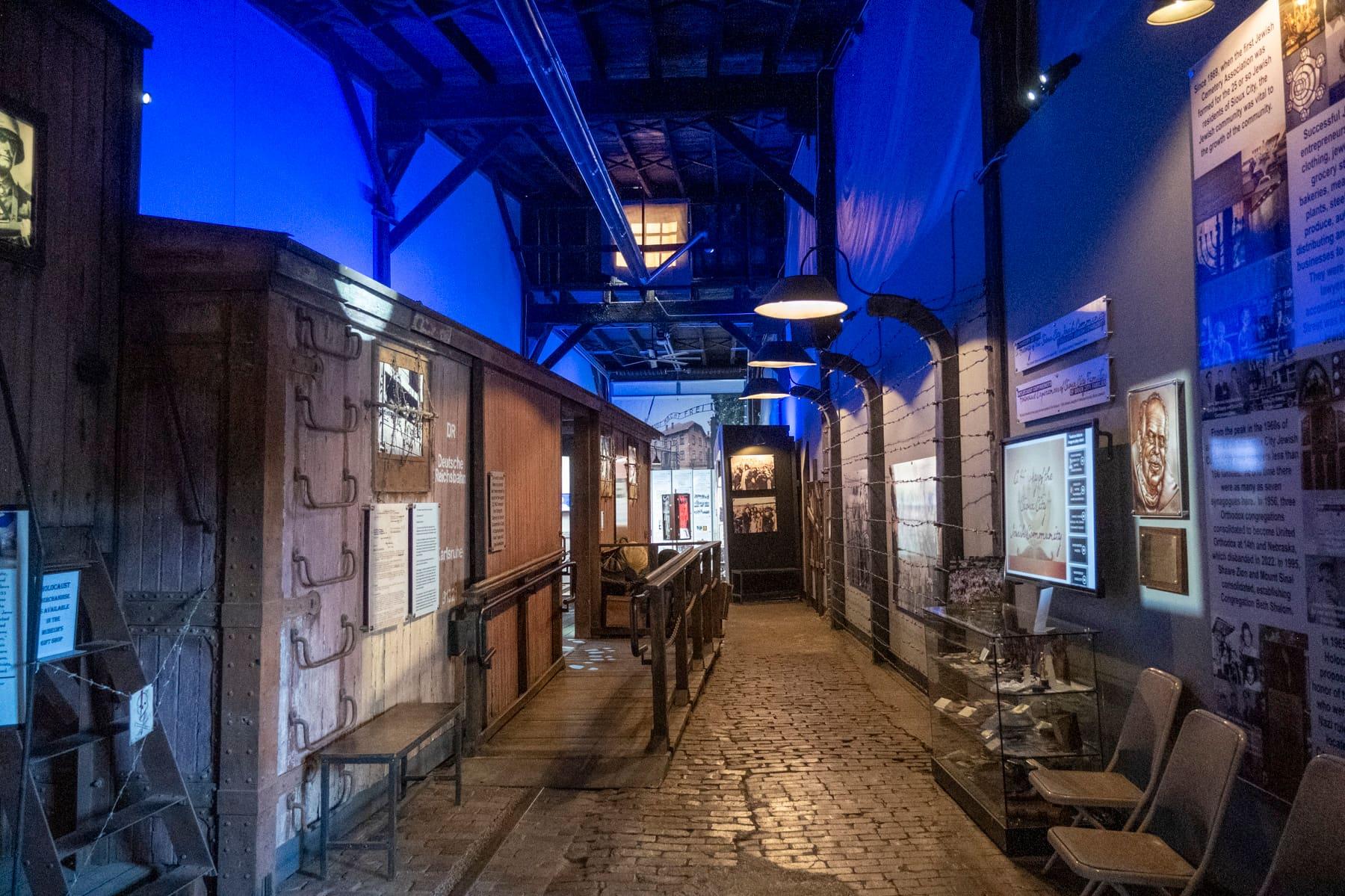 Brick exhibit walkway between a wooden railcar and illuminated displays