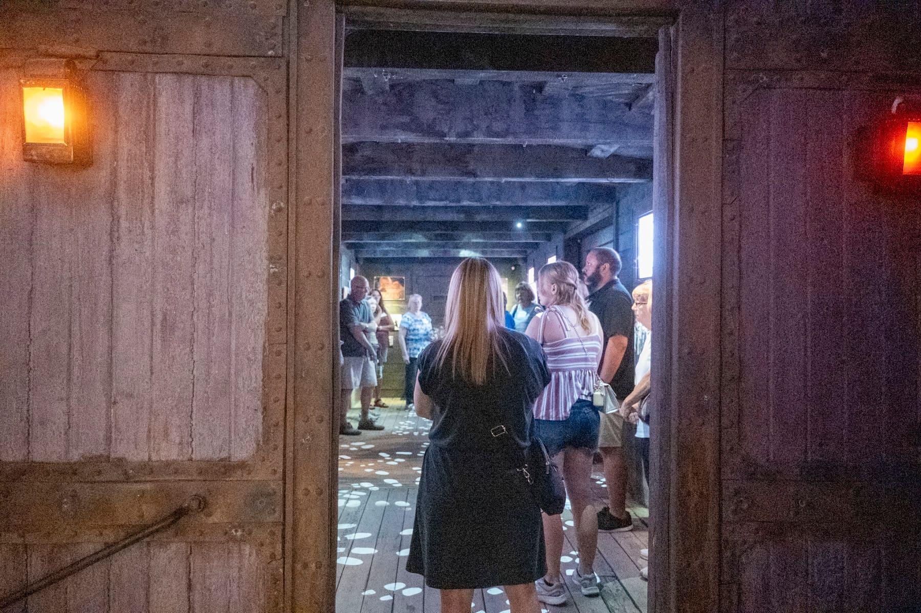 Visitors entering through an open wooden railcar doorway