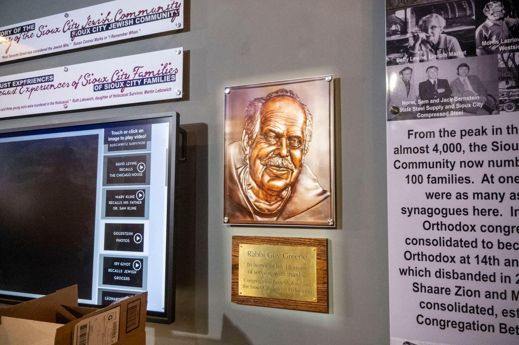 Bronze relief portrait mounted beside historical interpretation panels