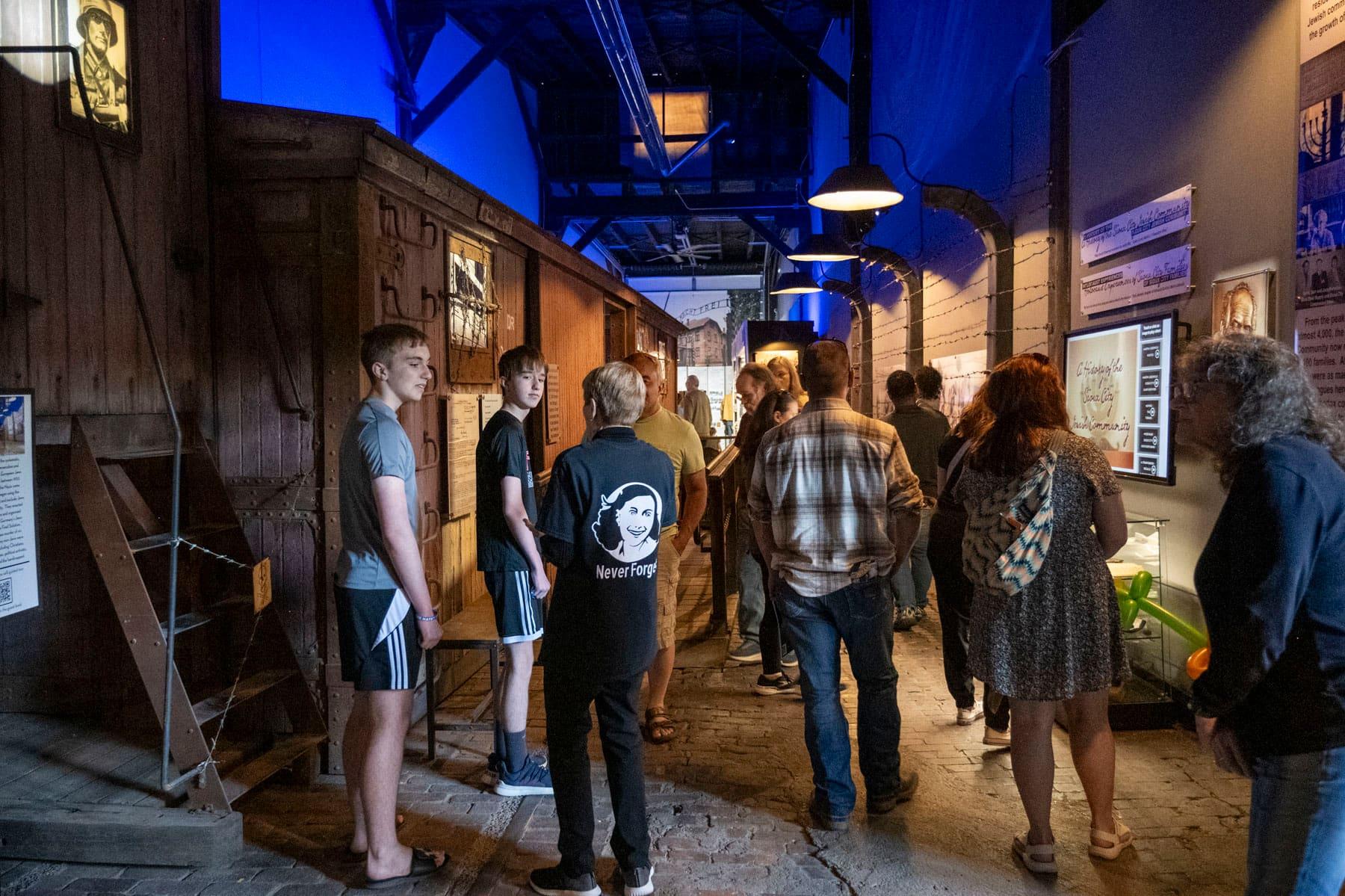 Visitors gathered beside a wooden railcar inside the exhibit