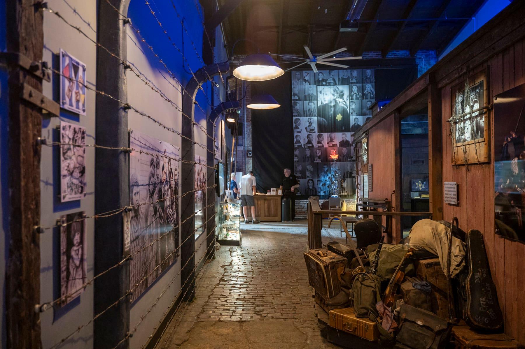 Brick walkway lined with luggage, portraits, and a wooden railcar wall