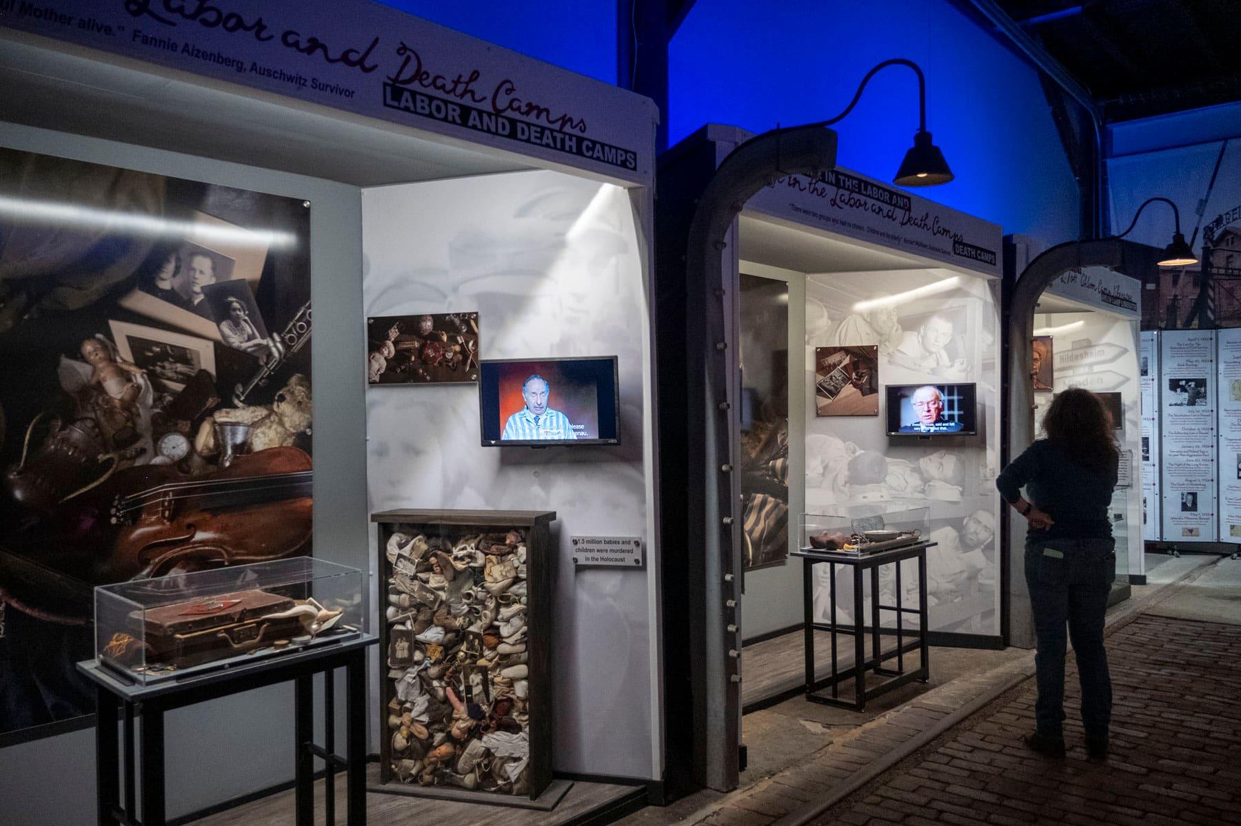 Visitor watching an exhibit video among Holocaust history displays