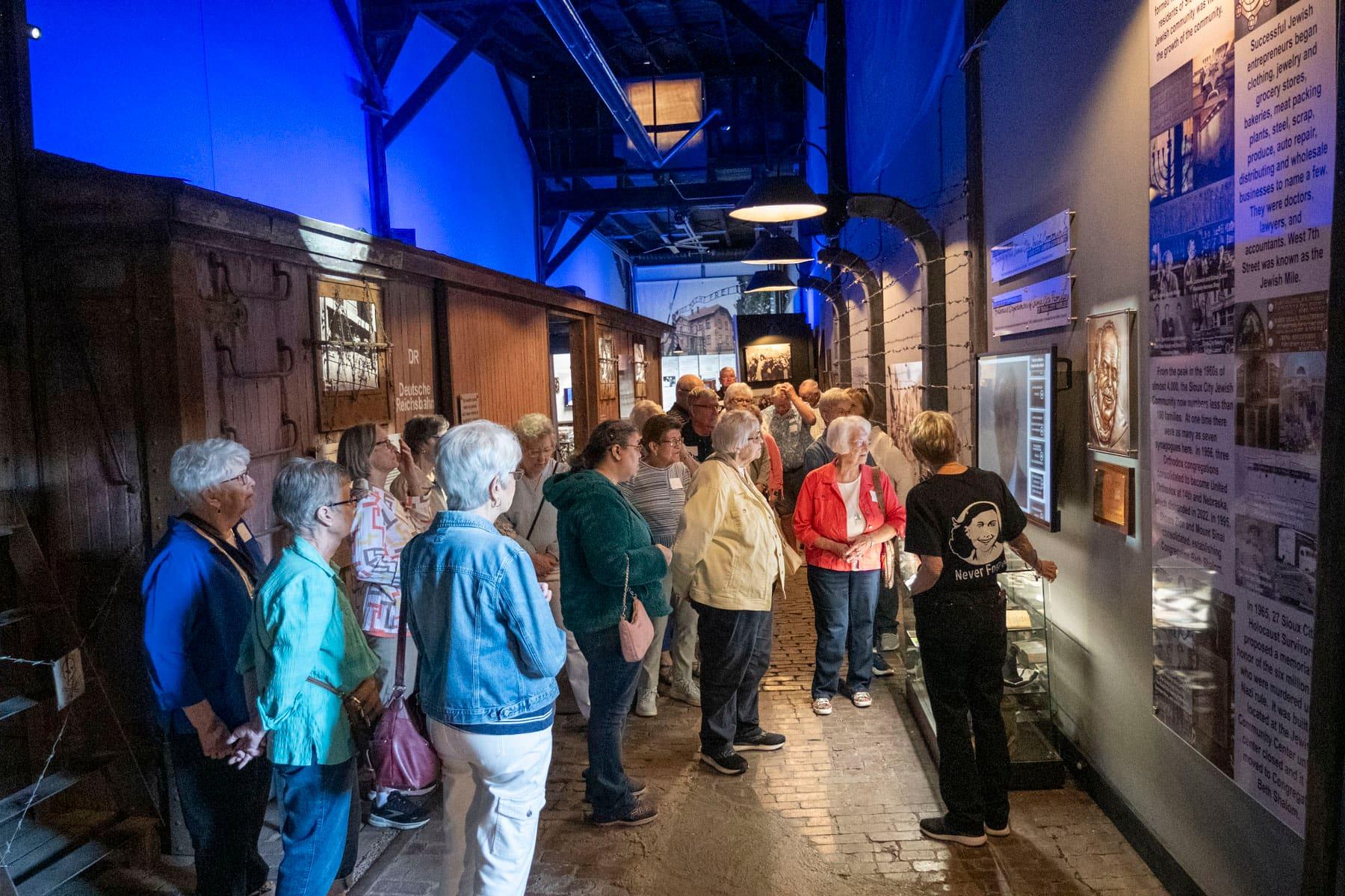 Guide speaking to a group of visitors in the exhibit corridor
