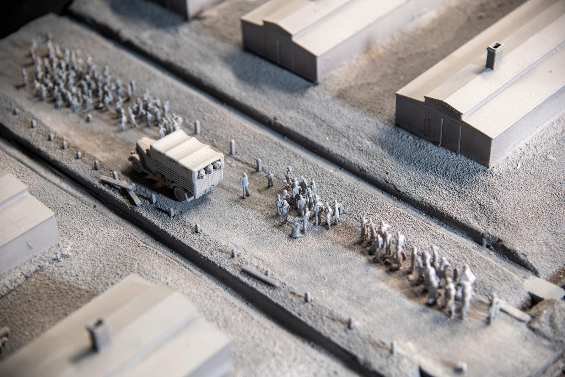HO-scale reconstruction of the Auschwitz-Birkenau arrival area, showing a truck, barracks, and groups of miniature figures