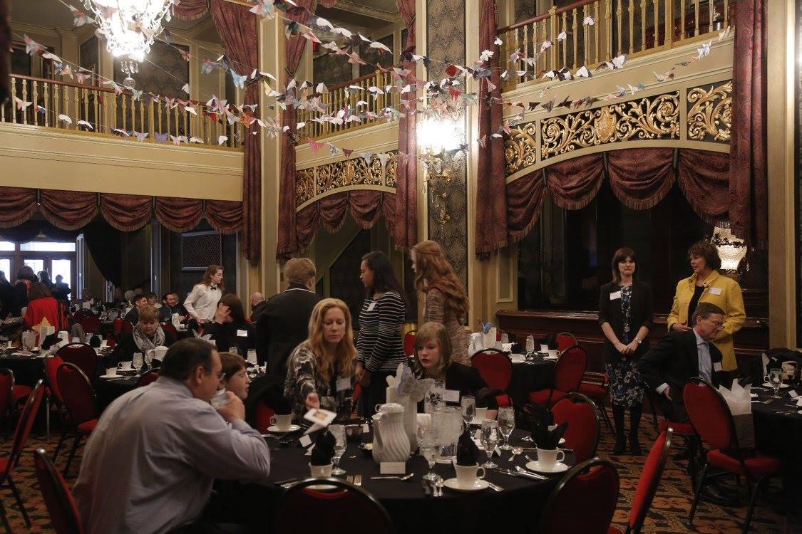 Banquet guests gather beneath ornate theater balconies.