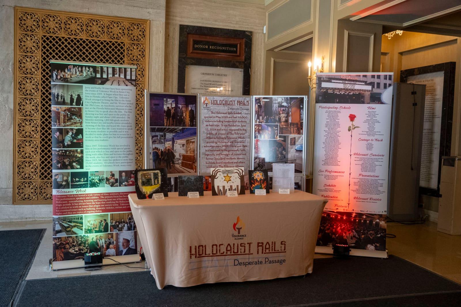 A Holocaust Rails information table stands between tall display banners.