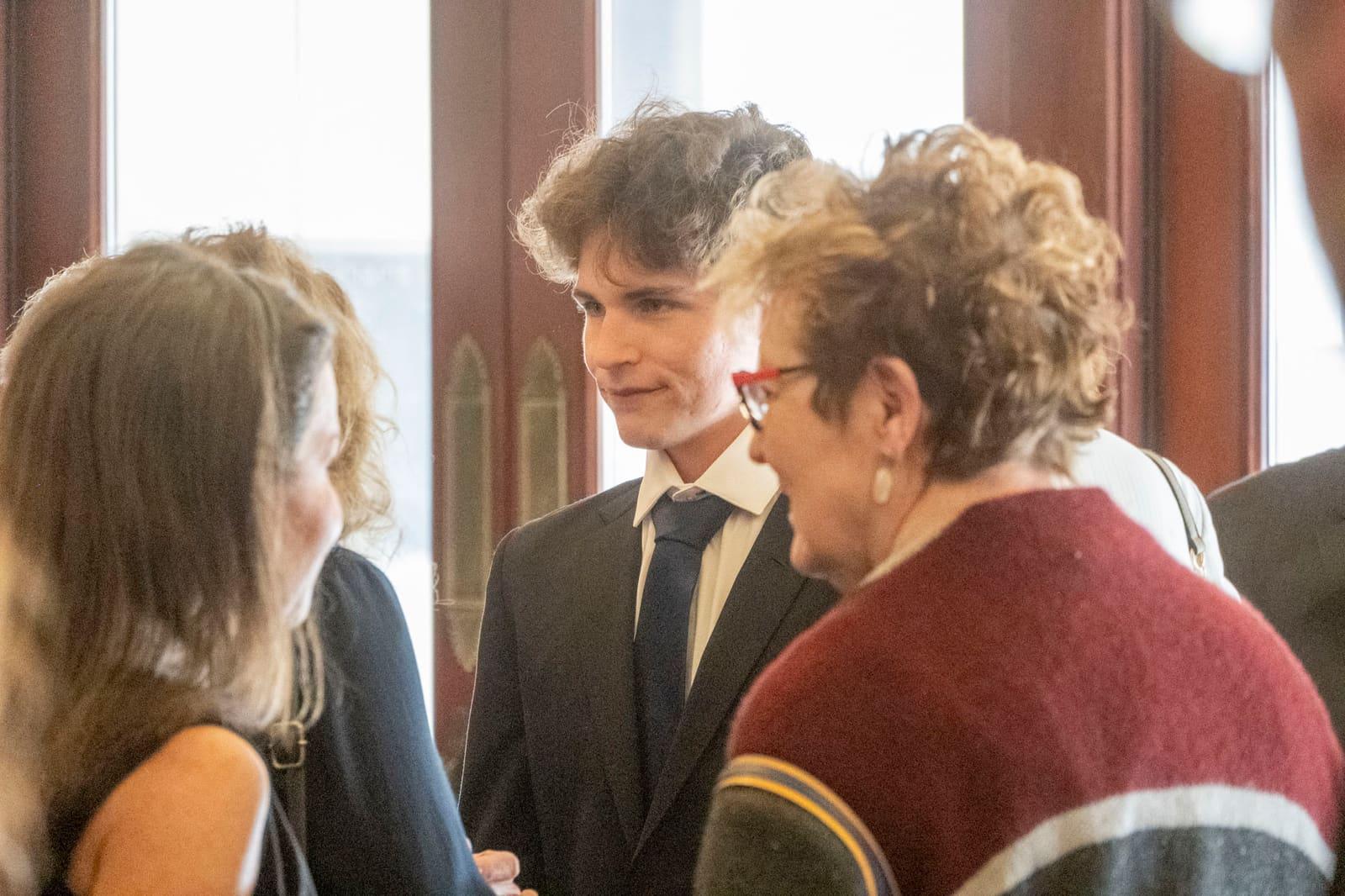 Several adults converse at an indoor reception.