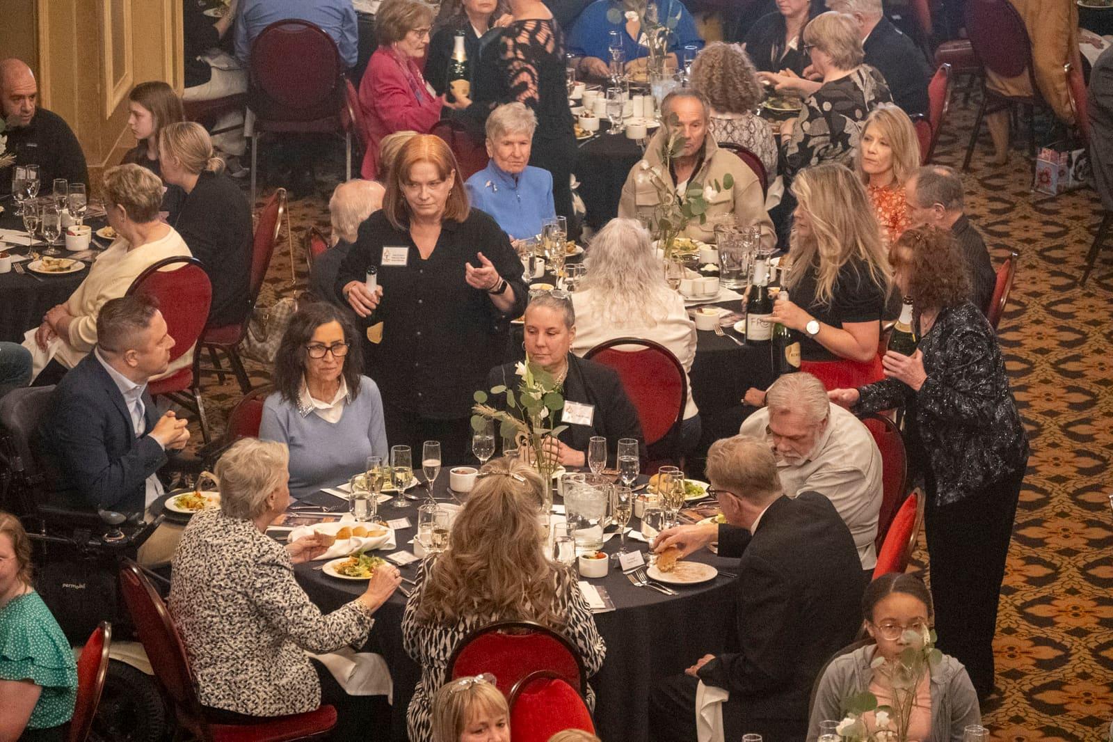 Banquet guests sit around several round tables.