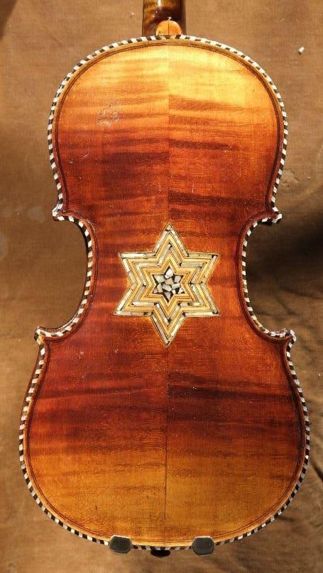 Back of a brown violin with a Star of David inlay.