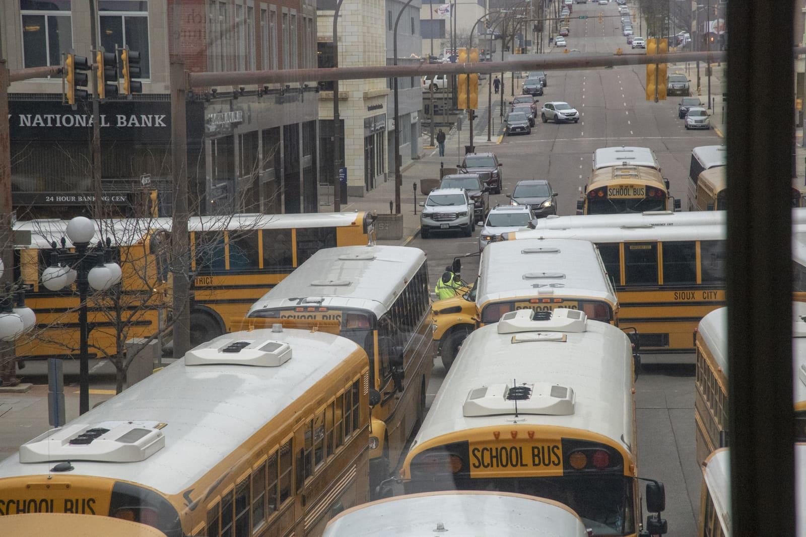 School buses line a city street viewed from above.