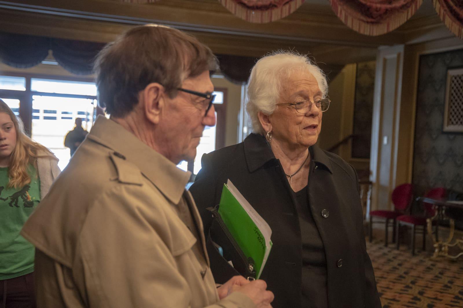 Two adults talk in a lobby.