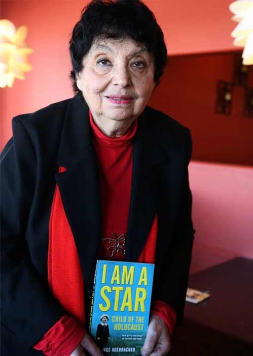 A seated adult holds a book titled “I Am a Star.”