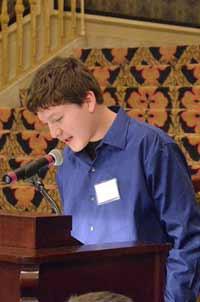 A student reads from a wooden lectern.