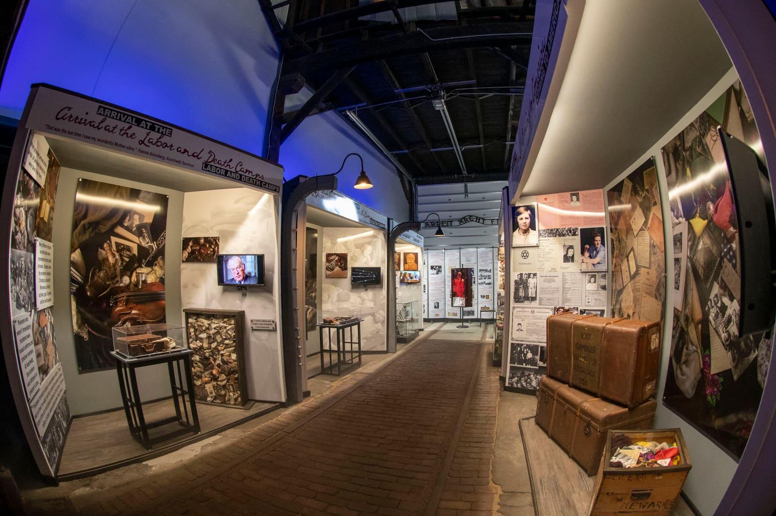 An exhibit walkway is lined with photographs, artifacts, and wood paneling.