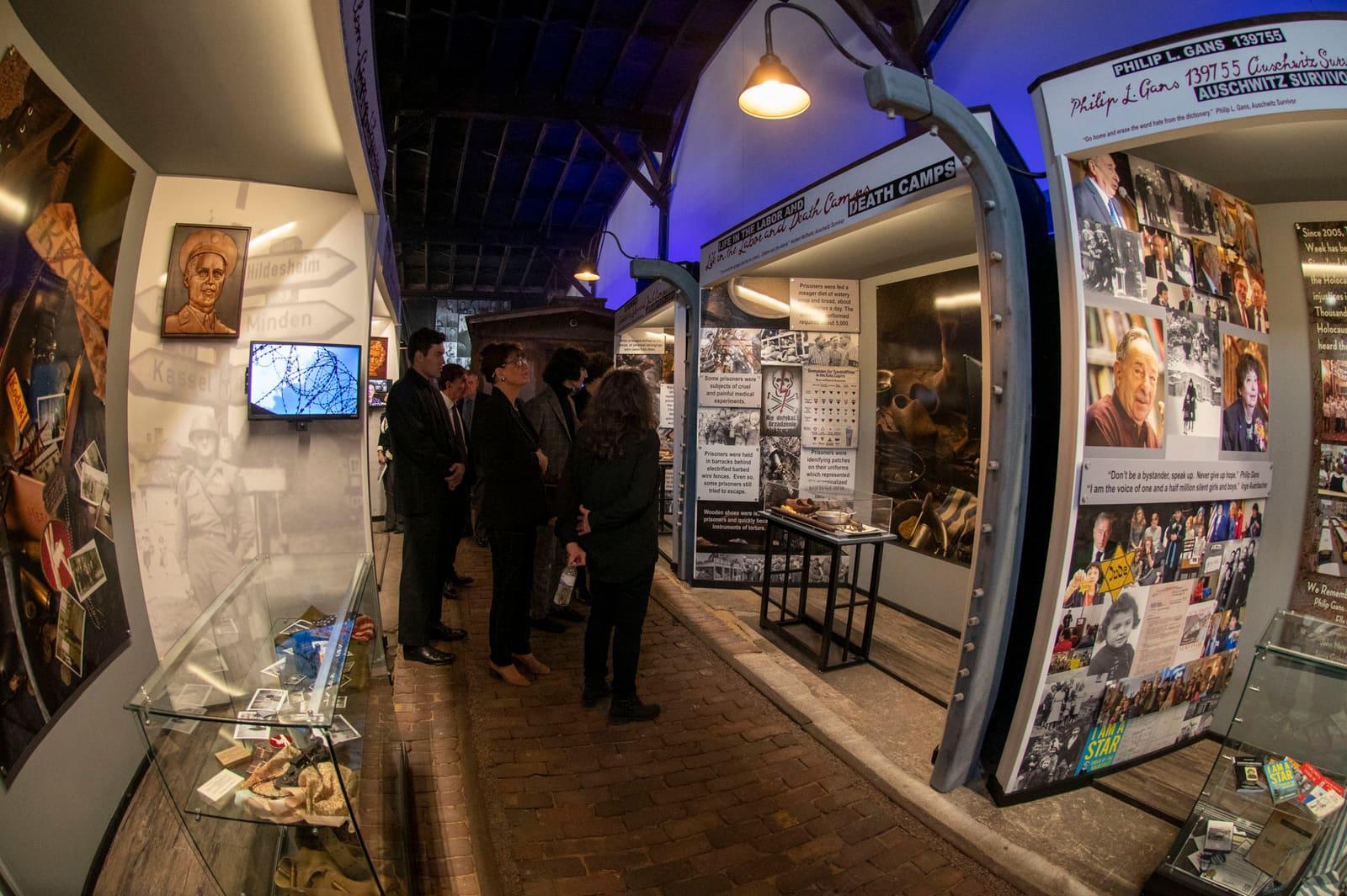 Adults stand together near illuminated historical displays.