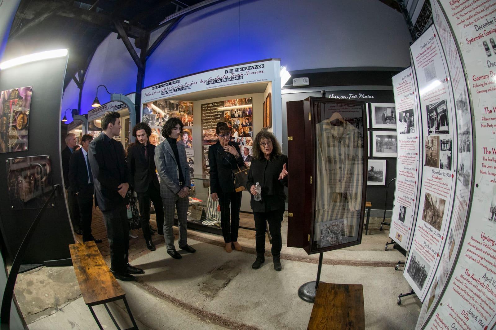 A group of visitors pose inside a historical exhibit.