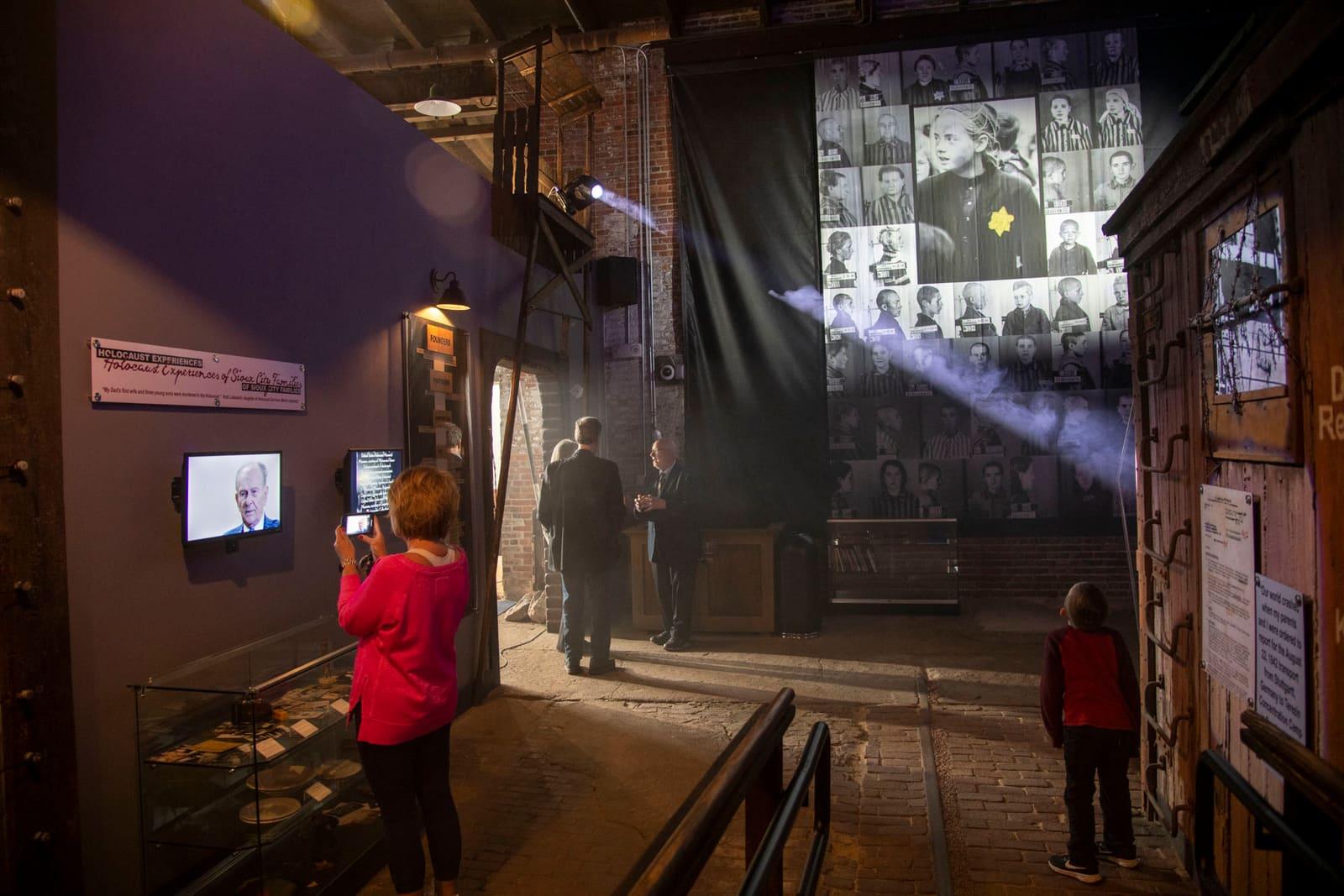 Two adults converse beside railway equipment and exhibit displays.