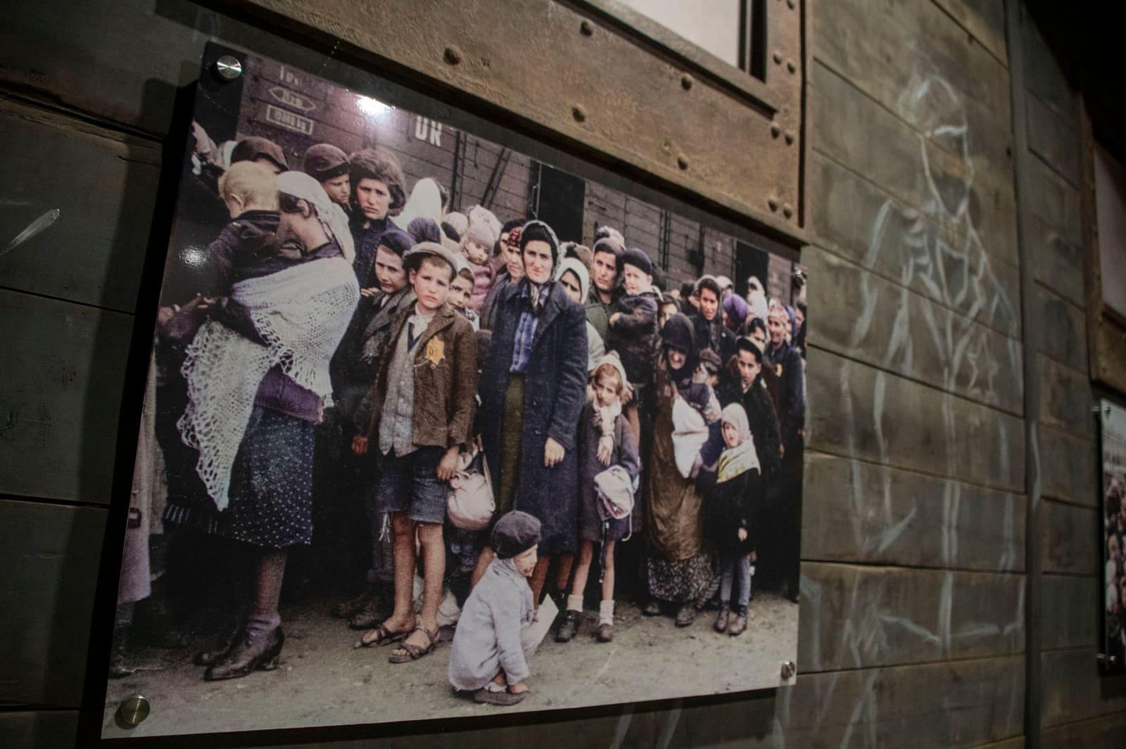 A framed group photograph hangs on a wooden wall.