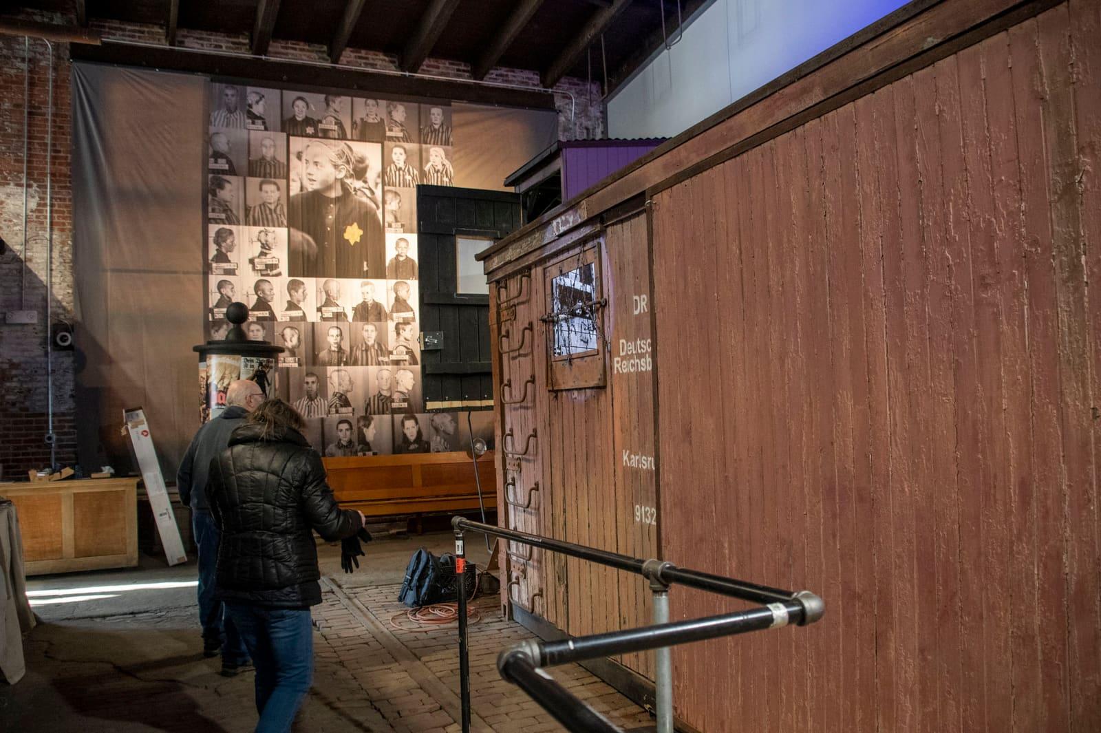 A visitor faces an illuminated historical wall display.