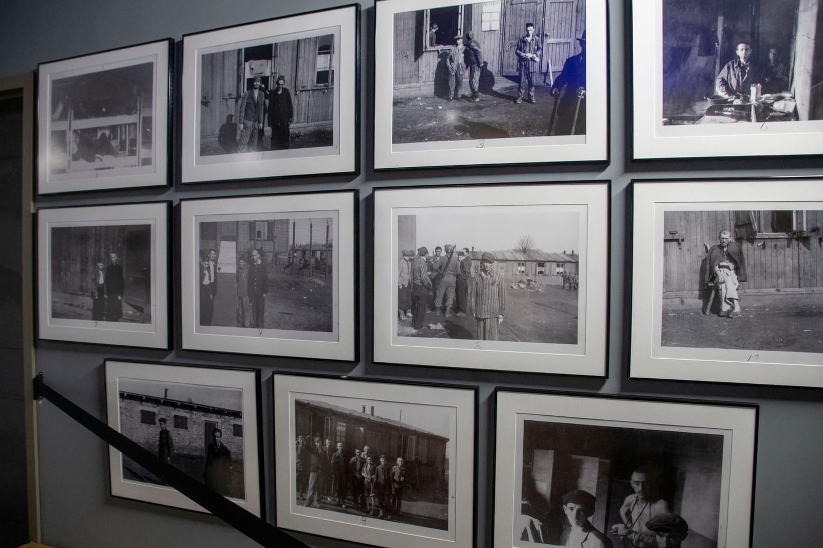 A grid of framed black-and-white historical photographs covers a wall.