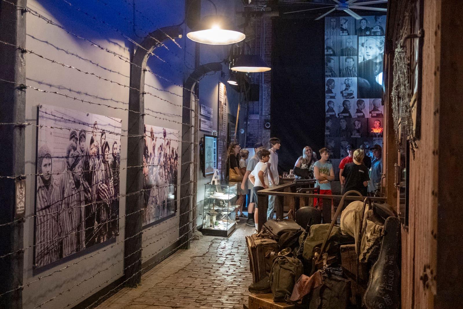 Luggage and historical panels line a narrow exhibit corridor.