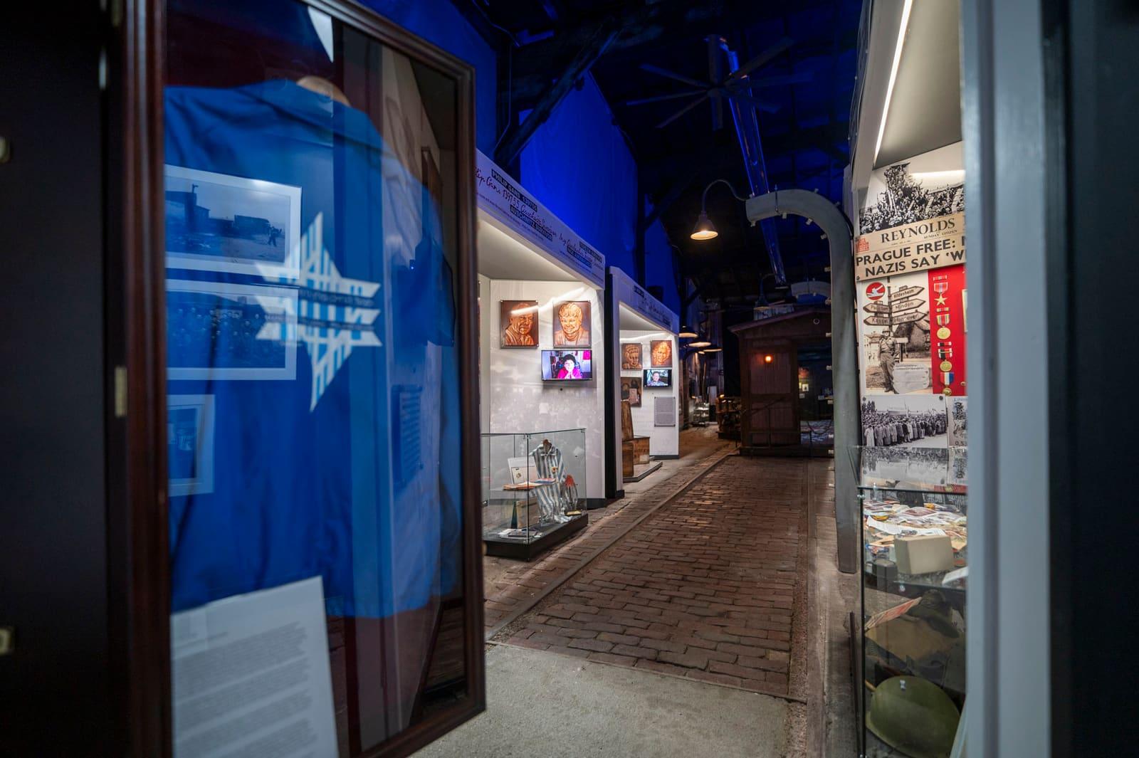 Display cases and historical panels line an indoor exhibit walkway.