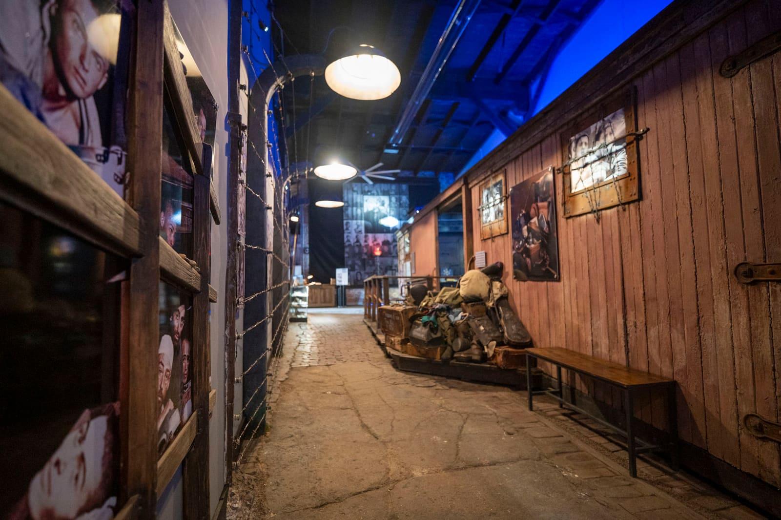 An empty corridor runs beside a wooden railcar wall and luggage display.