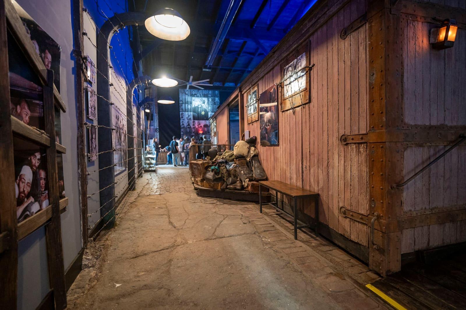 A narrow exhibit corridor runs beside a wooden railcar wall.