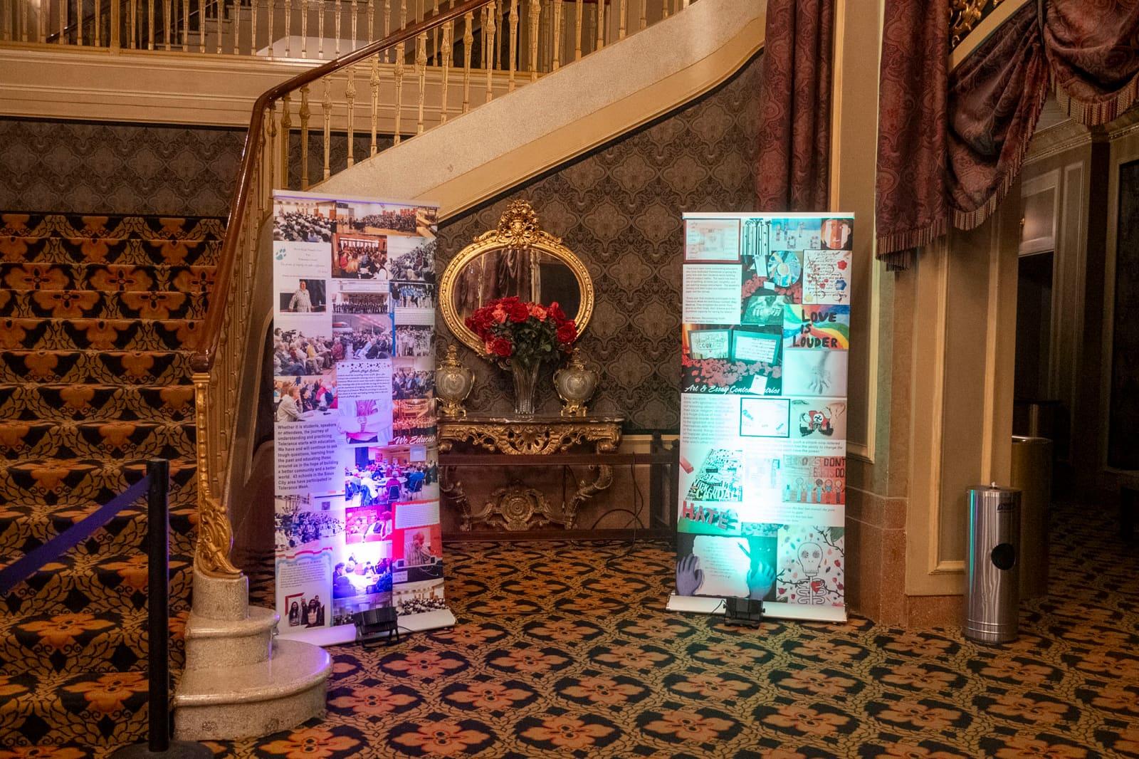 Illuminated Holocaust Rails banners flank a wooden lectern.