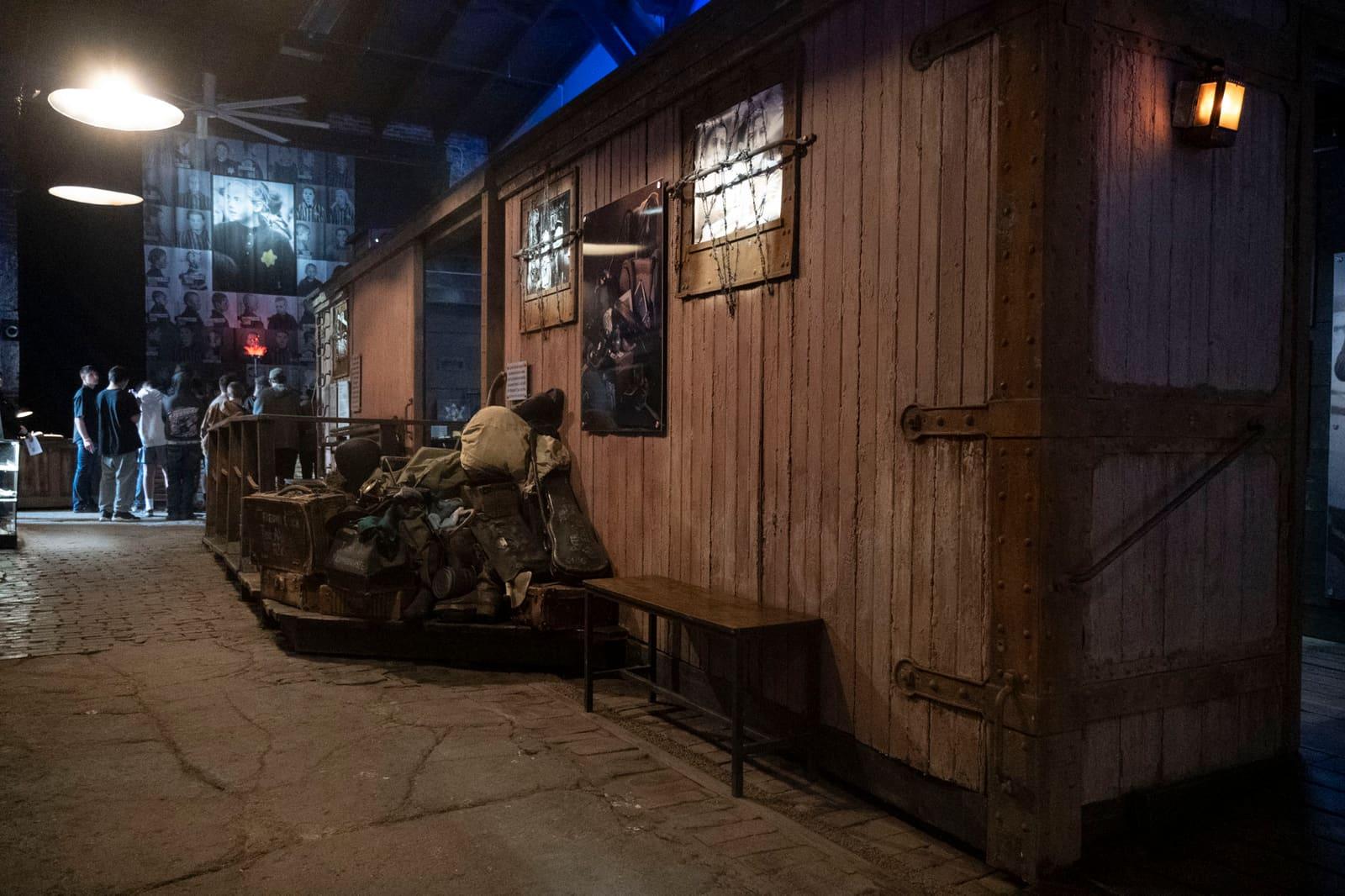 An empty exhibit corridor runs beside a wooden railcar wall.