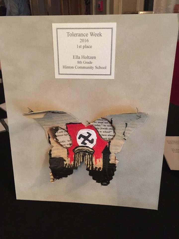 Mounted butterfly artwork with torn text, a red Nazi flag motif, and a printed first-place label.